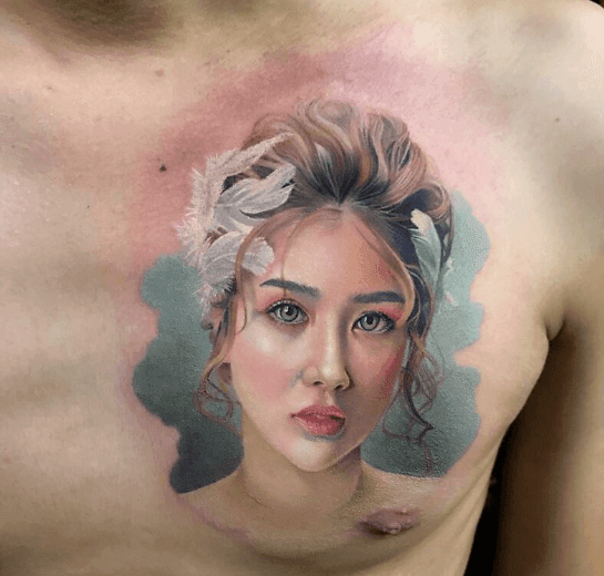 Realistic portrait tattoo of a woman's face on a person's chest.
