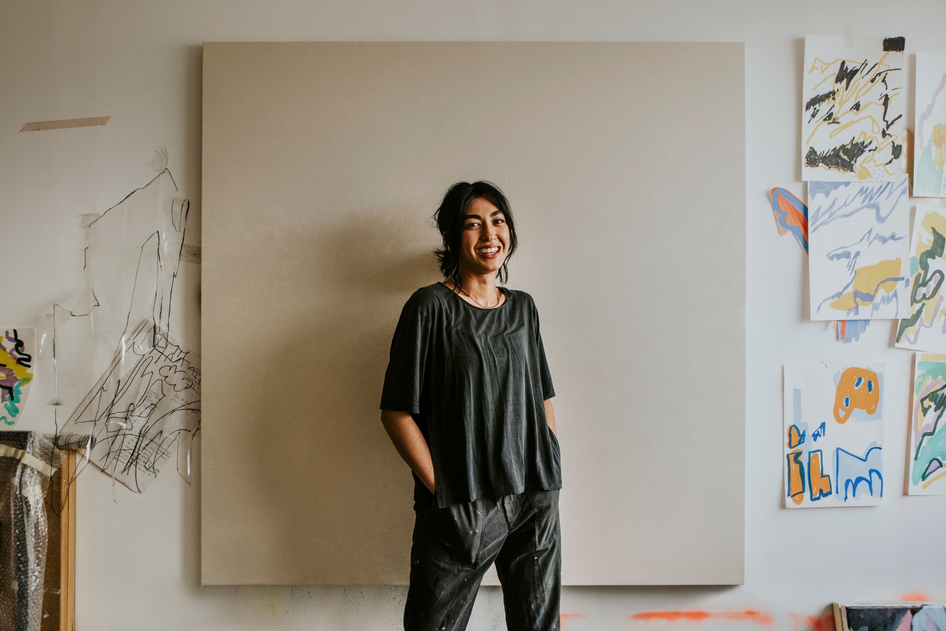 Female artist standing in front of a big blank canvas