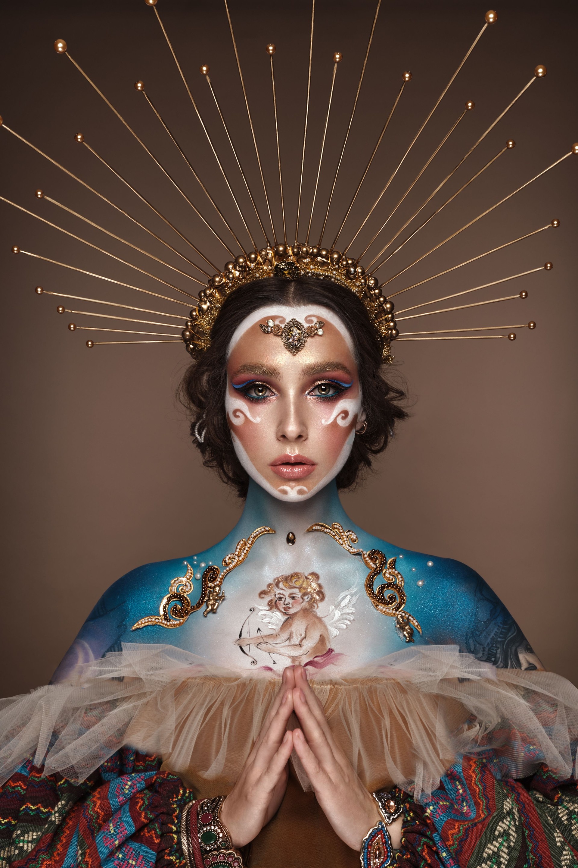 Portrait of a girl with gold and blue creative art make-up.